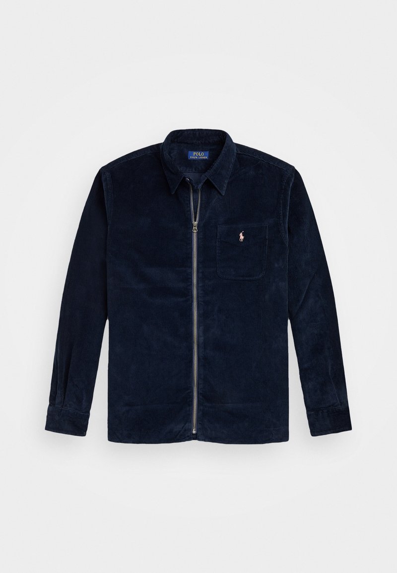 Tummansininen corduroy-tyylinen vetoketjullinen takki, jossa on kaulus, rintatasku, jossa on pieni vaaleanpunainen Polo Ralph Lauren -logo, pitkät hihat ja napilliset hihansuut.