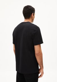 Zwart T-shirt met korte mouwen van katoen, voorzien van een ronde hals en een rechte zoom. De achterkant laat een comfortabele pasvorm en een gladde textuur zien.