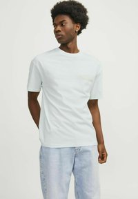 Lichtblauwe katoenen t-shirt met een ronde hals en korte mouwen, met een subtiel textuurontwerp op het gebied van de linker borstzak.