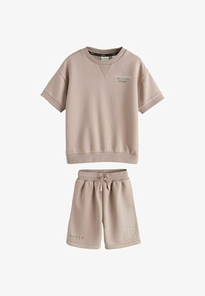 Beige korteærmet sweatshirt og matchende shorts med snøre, med "Baker" og "TB" logoer på brystet og benet.