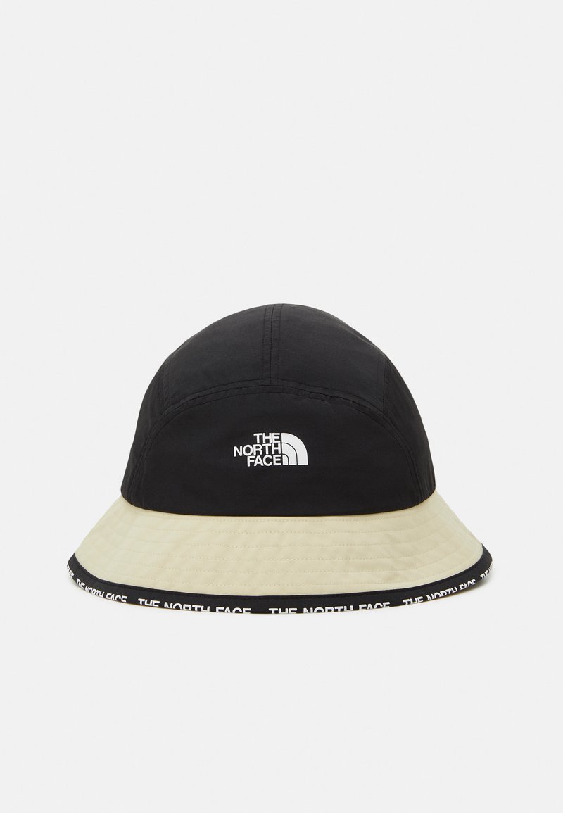 Cappello a secchiello con parte superiore nera e visiera color crema. Presenta un logo bianco e una fascia del marchio a contrasto lungo il bordo. Realizzato in materiale leggero.