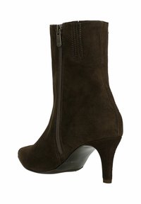 Hnědé semišové kotníkové boty s špičatou špičkou a 7 cm vysokým jehlovým podpatkem. Mají boční zip pro snadné obouvání a prošívané detaily.