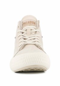 Zapatillas de color beige claro con una suela de goma texturizada, punta redonda y cierre de cordones de algodón. Presentan un logo "PALLADIUM" en la lengüeta.