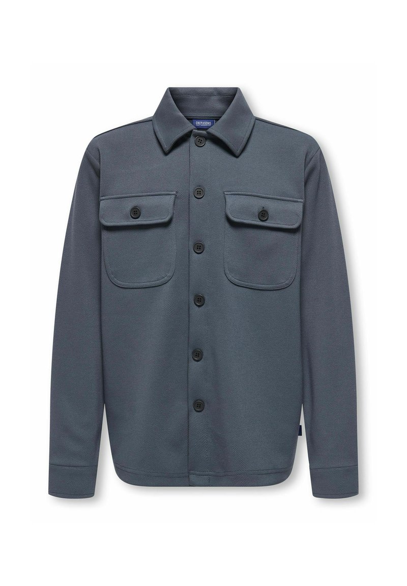 Pelēks pogājams krekls-jakā ar divām krūšu kabatām, izgatavots no teksturēta auduma, ar apkakli un melnām pogām.