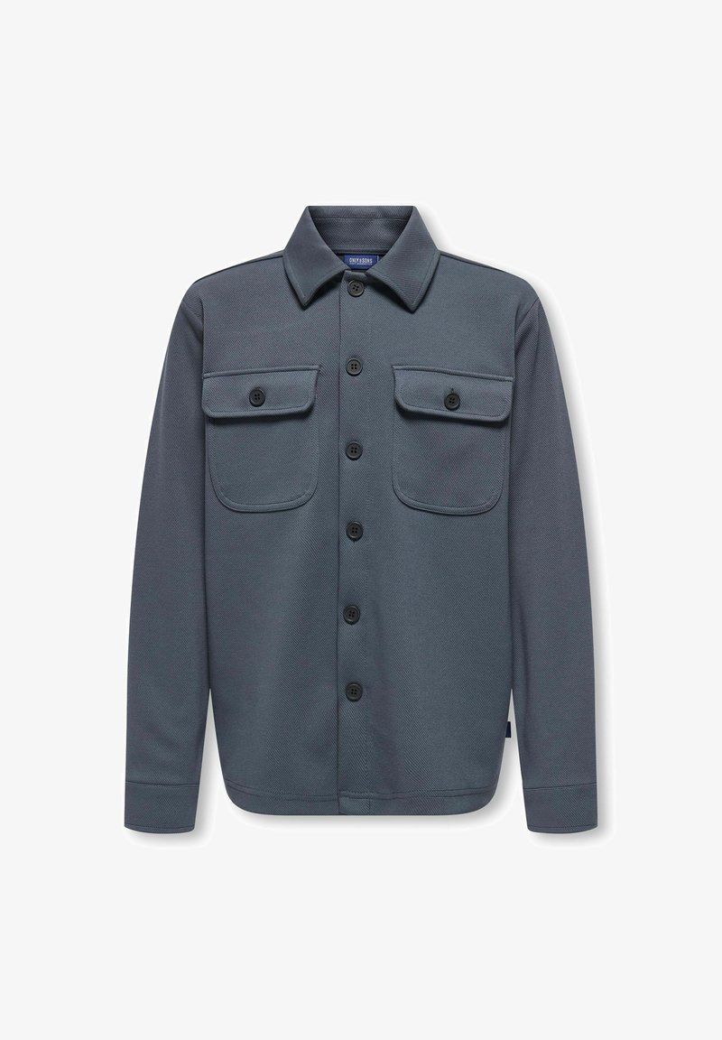 Camisa chaqueta gris abotonada con dos bolsillos en el pecho, hecha de una tela texturizada, con cuello y botones negros.