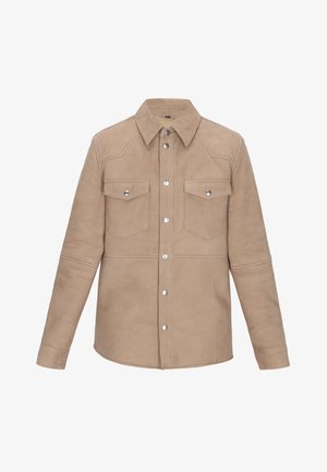 Veste beige à manches longues avec boutons, col pointu, deux poches poitrine à rabat avec boutons-pression et coutures visibles.