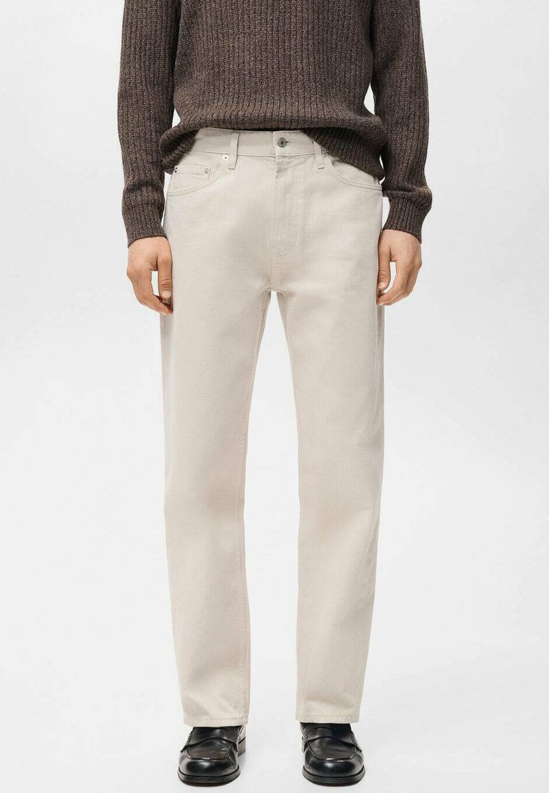 Pantalones de algodón beige claro con corte recto, con bolsillos delanteros y bragueta clásica con botones, combinados con un suéter acanalado marrón oscuro.
