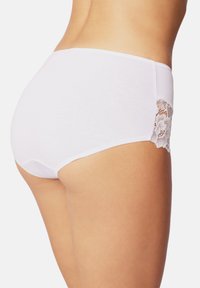 Witte katoenen panties met een hooggeklede uitstraling en kantdetails aan de zijkanten, die een gladde textuur en een klassieke silhouet tonen.