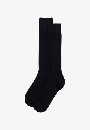 Calze di cotone nere con una texture liscia, un bordo a costine nella parte superiore e un design di lunghezza standard. Nessun motivo o dettaglio visibile.