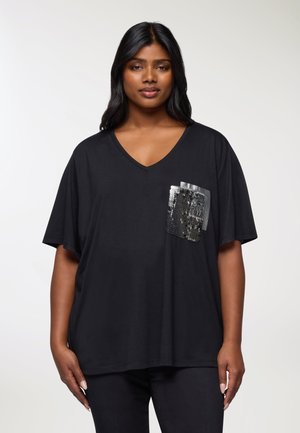 T-shirt di cotone nero con scollo a V e maniche corte. Presenta una tasca applicata con paillettes argento e nere. Vestibilità comoda.