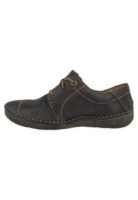 Scarpa in pelle nera con punta tondeggiante, design con lacci, cuciture marroni a contrasto e un piccolo accento rosso vicino agli occhielli. Texture morbida.