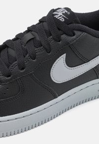 Juodas odinis sportbaigis su pilkiais akcentais, turintis apvalų pirštą, tekstūruotą paviršių ir storą guminį padą su grioveliais.