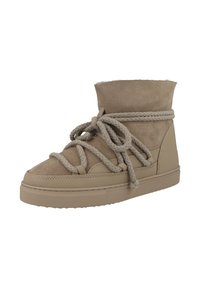 Tan mid-top sneakers med ovandel i mocka, breda flätade skosnören och gummisula. Har en något rundad tå och en mjuk vaddering runt ankeln.