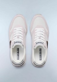 Sneakers rosa chiaro e bianchi con una parte superiore in camoscio e tessuto, lacci bianchi e una patch nera con logo sul lato. Suole in gomma con dettagli a righe.