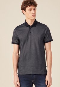 Polo shirt grigio scuro realizzato in tessuto testurizzato, con colletto e polsini neri, tre bottoni al collo e maniche corte.
