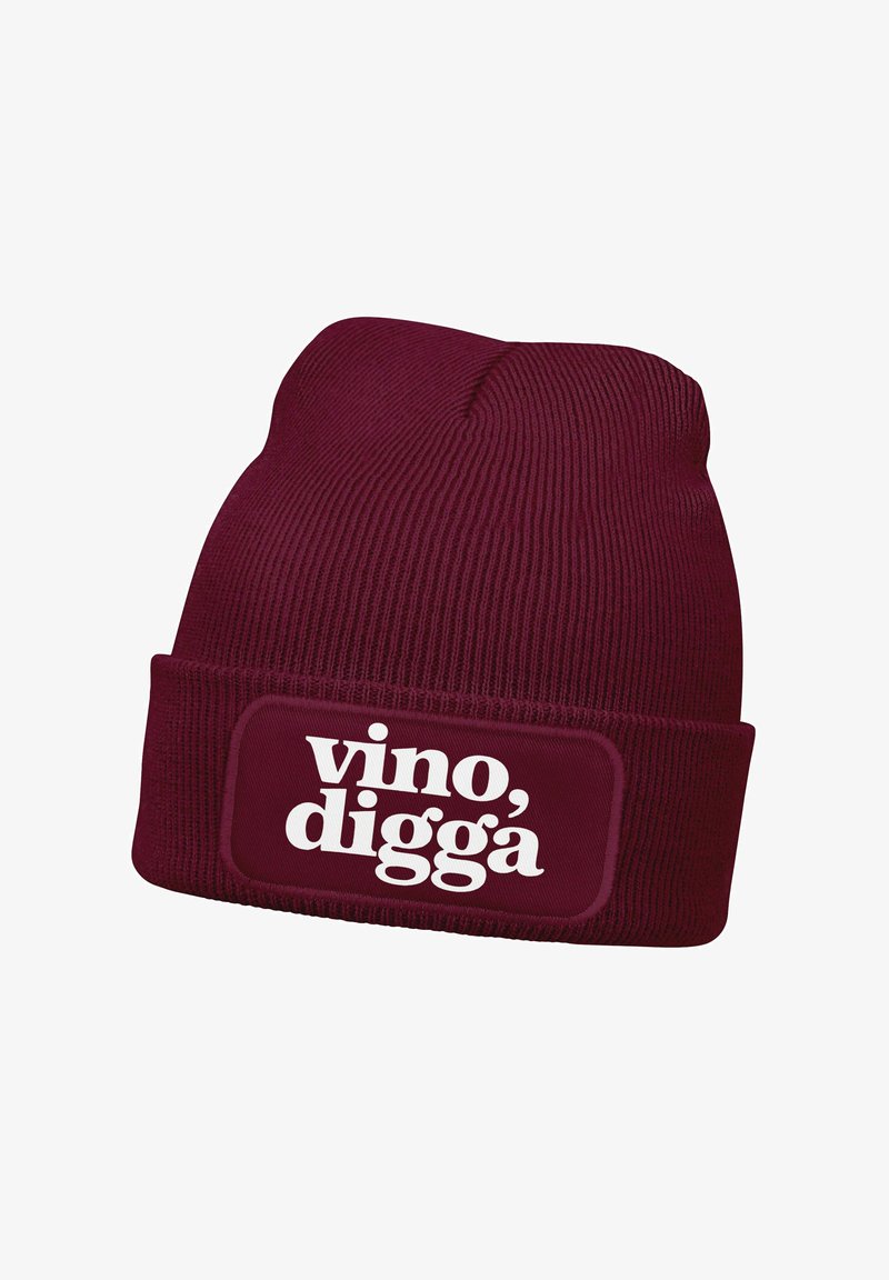 Burgundy knit beanie with a folded cuff featuring a rectangular patch; white text reading "vino, digga" on the front. Textured fabric.