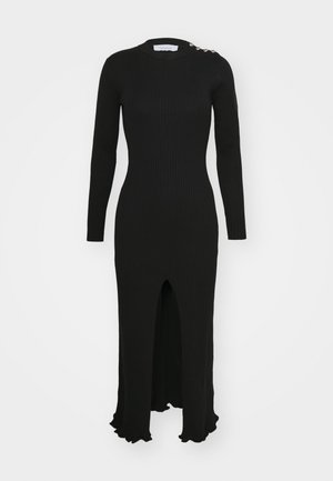 Schwarzes geripptes Langarmkleid mit hohem Kragen, Frontschlitz und gewelltem Saum. Verfügt über dekorative Knopf-Akzente an der Schulter.