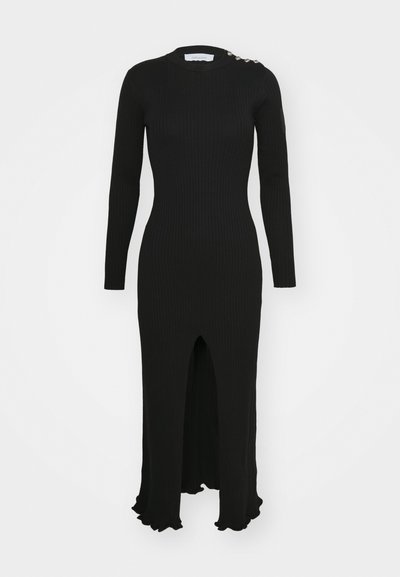 Fekete bordázott, hosszú ujjú ruha magas nyakkivágással, elülső hasítékkal és fodros szegéllyel. Díszítő gomb részletekkel a vállon.