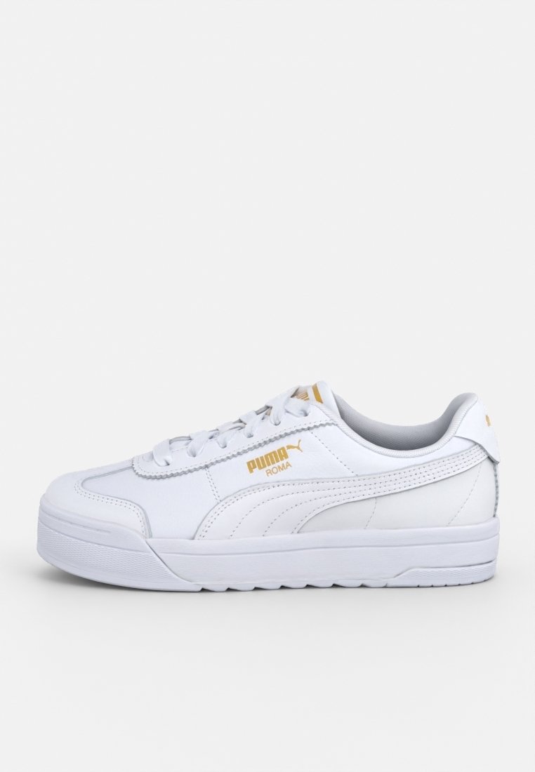 Baskets blanches Puma Roma avec logo doré, design à lacets et semelle texturée, vues du côté extérieur sur un fond clair.