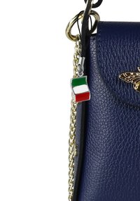 Sac en cuir navy avec une surface texturée, bandoulière en chaîne dorée et un petit charm du drapeau italien accroché à la tirette.