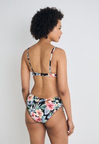 Blomsterbikini med svart bakgrunn og fargerike hibiscus- og bladmønstre. Justerbare stropper og klassisk snitt på bunnen.