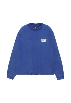 Niebieska bluza z długim rękawem i okrągłym dekoltem, z żółtym napisem "STWD COMMUNITY" na lewej piersi, ściągacze przy mankietach oraz czarną metką wewnątrz kołnierza.