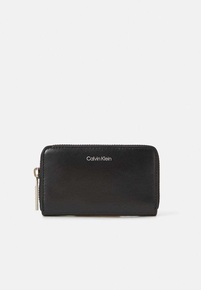 Portafoglio zip in pelle nera con logo impresso, texture liscia e hardware in tonalità argento. Design compatto con forma arrotondata.