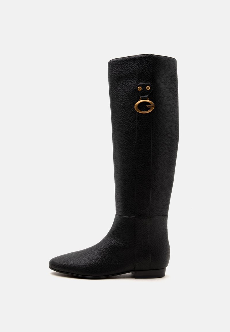 Botte haute en cuir noir avec un bout rond et un petit détail de boucle ovale dorée près du haut sur fond blanc.
