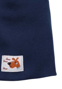 Navy blue ribbed fabric with a rectangular white label featuring an illustration of a dog and the text "How How How."