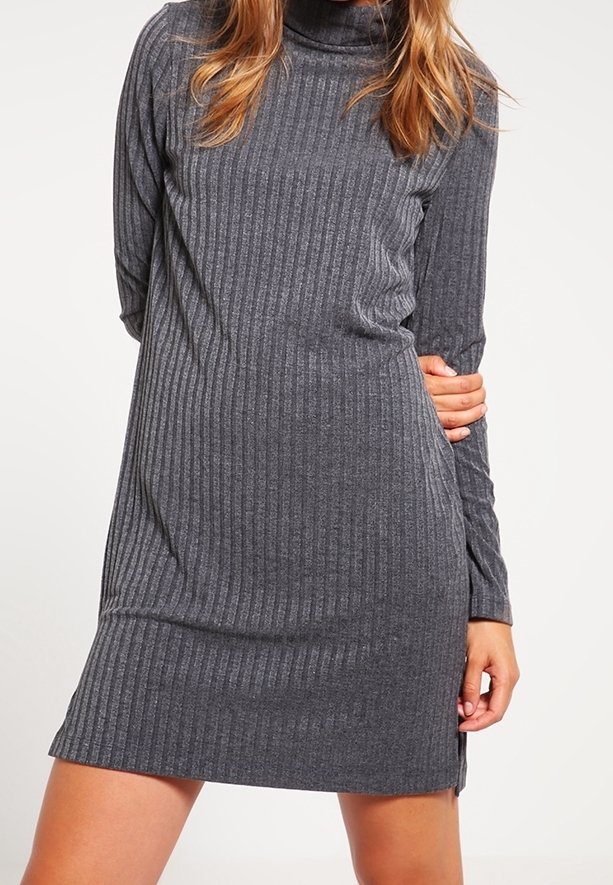 Abito grigio a coste con collo alto, maniche lunghe e spacchi laterali, caratterizzato da una texture morbida e un design che arriva a metà coscia.