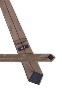 Cravate marron foncé en tissu lisse, présentant une texture unie et des extrémités angulaires. Comprend une étiquette bleue avec "JOOP!" en lettres blanches.