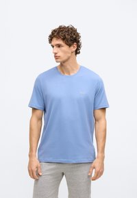 T-shirt de algodão azul claro com decote redondo e mangas curtas, apresentando um discreto logótipo "BOSS" no peito. Textura macia.