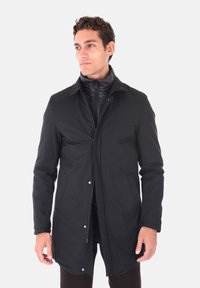 Cappotto esterno nero con chiusura a bottoni, dotato di uno strato interno con zip. Realizzato in tessuto liscio, con una vestibilità su misura e maniche lunghe.