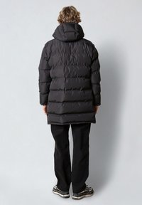 Cappotto imbottito nero con cappuccio, caratterizzato da un design trapuntato e una linea dritta. Accentuato da polsini elasticizzati e tasche laterali.