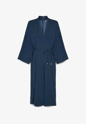 Marineblauwe wikkeljurk met lange mouwen, v-hals en gestrikt riempje. Gladde stof met een lichte textuur en verticale plooien voor extra vloeiendheid.