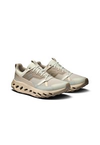 Laufschuhe mit einem leichten, atmungsaktiven Mesh-Obermaterial in hellbeige und mintgrün, ausgestattet mit einer gepolsterten Sohle und einem betonten Profil-Design.