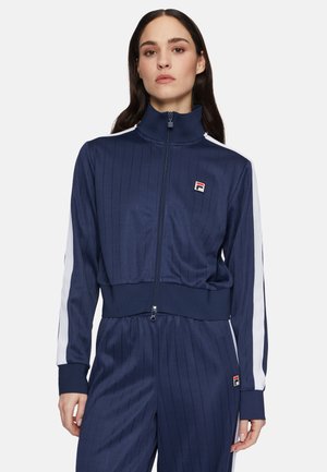 Navy track jacket with vertical pinstripes, white side stripes, high collar, and zip closure. Features Fila logo on chest.