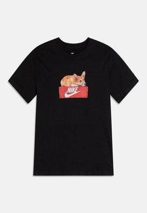 T-shirt noir avec un motif imprimé d'un corgi allongé à l'intérieur d'une boîte à chaussures rouge Nike, centré sur la poitrine.