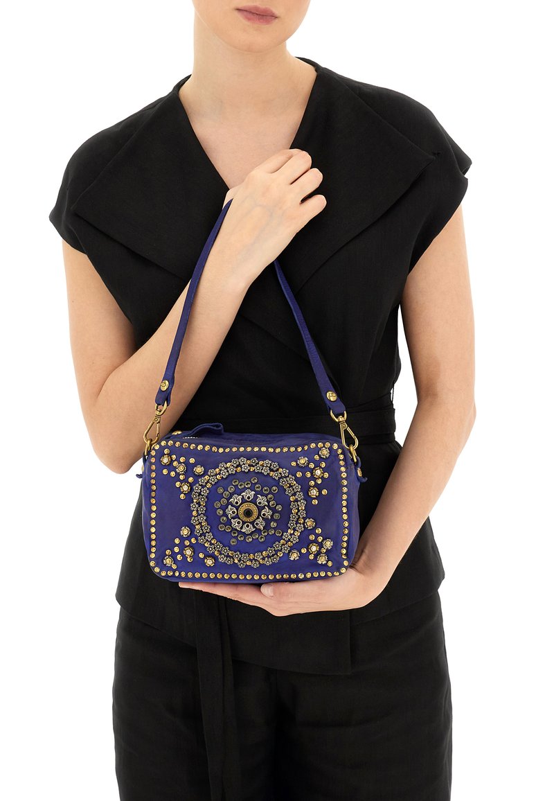 Borsa a tracolla viola con embellishments in tonalità oro, motivo circolare, forma rettangolare, tracolla rimovibile e dettagli in superficie testurizzati.