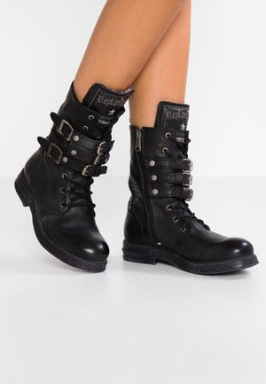Bottines en cuir noir avec un bout rond, laçage à l'avant, fermeture éclair sur le côté et plusieurs accents de boucles. Semelle texturée pour une meilleure adhérence.