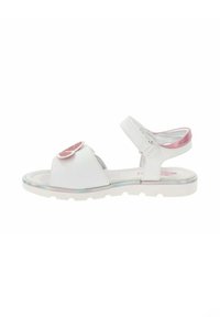 Sandalias blancas con suela plana, correa ajustable en el tobillo y un adorno de flor de purpurina rosa. Material sintético suave y diseño de punta redondeada.