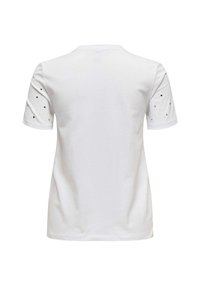 Camiseta blanca con escote redondo y mangas cortas. Las mangas presentan detalles decorativos de tachuelas negras. Tejido de algodón suave, corte relajado.