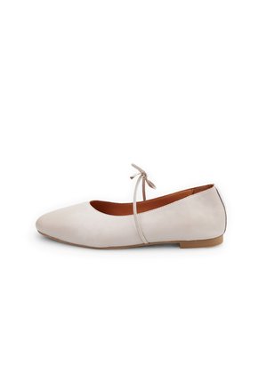 Ballet flats dalam kulit beige lembut, reka bentuk hujung runcing, tali pergelangan kaki nipis dengan perincian reben, tapak rata, gaya minimalis dengan tekstur licin.