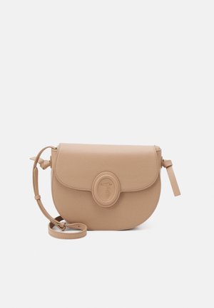 Světlé béžové kožené crossbody taška s zaobleným klopě, kulatým logem a nastavitelným popruhem. Hladký povrch, minimalistický design.