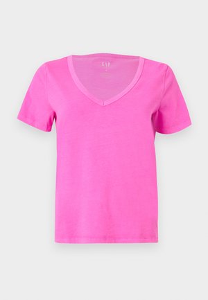 Φωτεινό ροζ κοντομάνικο T-shirt με V-λαιμόκοψη και λεία υφή, σε απλό ανοιχτό γκρι φόντο.