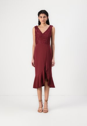 Bordeaux kjole med en blomsterlaced bodice, V-hals og en flared kant. Blødt stof med et bølget lag ved kanten af nederdelen.