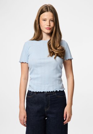 Lys blå ribbestrikket topp med korte ermer, bølgete kanter og en tettsittende design, kombinert med mørke høy midje jeans.