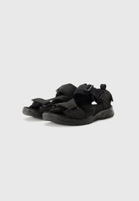 Black sandals featuring adjustable straps, textured material, open toe design, and a durable rubber sole for traction.