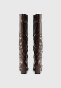 Smeđe lažne kožne čizme do koljena sa opuštenim dizajnom, kvadratnim petama i glatkom površinom. Nema ukrasa ili uzoraka.