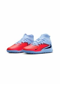 Nike fodtøj med et gradientdesign fra rød til lys blå, featuring en tekstureret overdel, blå snørebånd og et sort logo. Mellem høj silhuet.